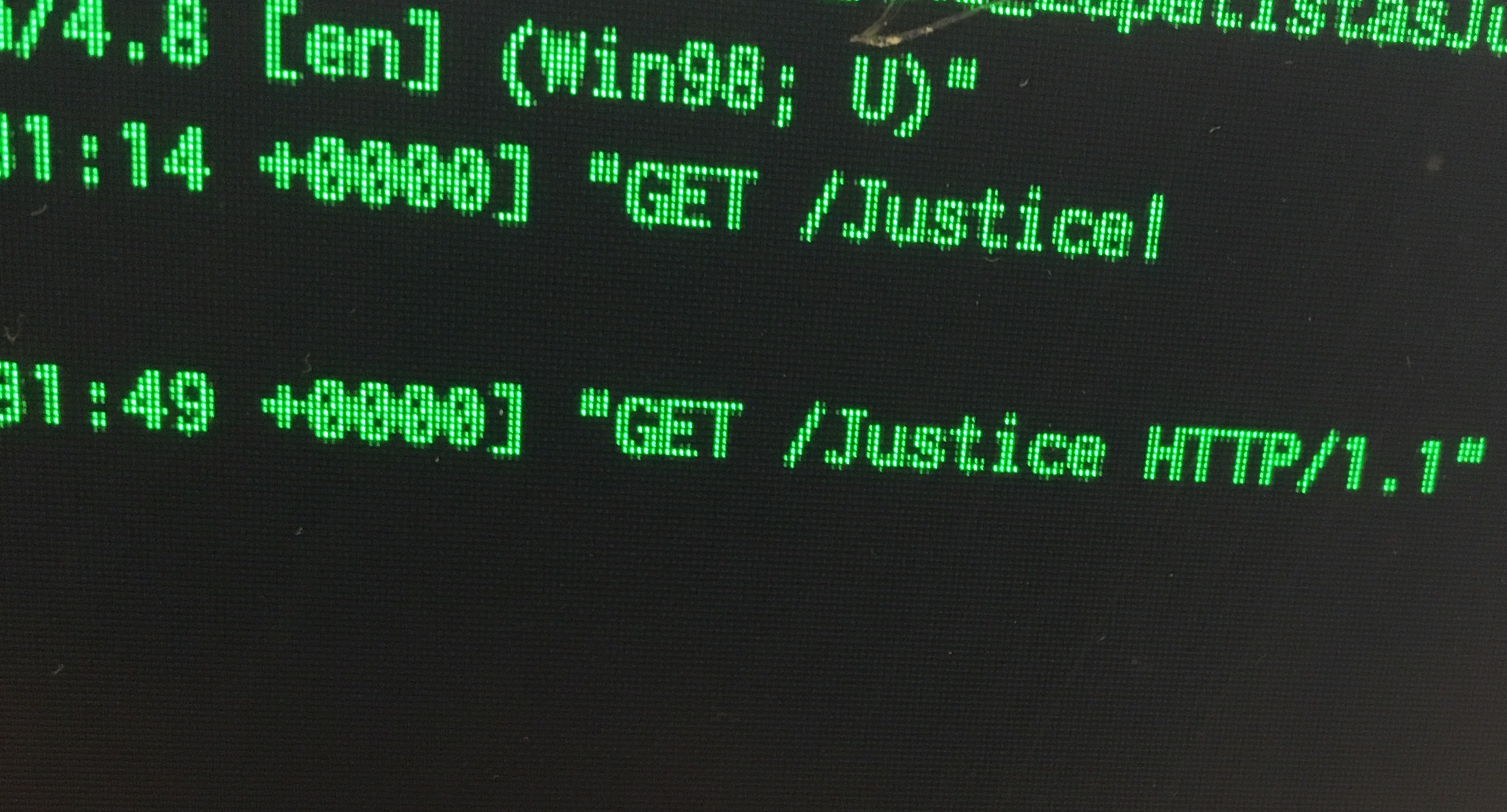 photograph of green text on computer screen reading: 'GET /Justice HTTP/1.1'.